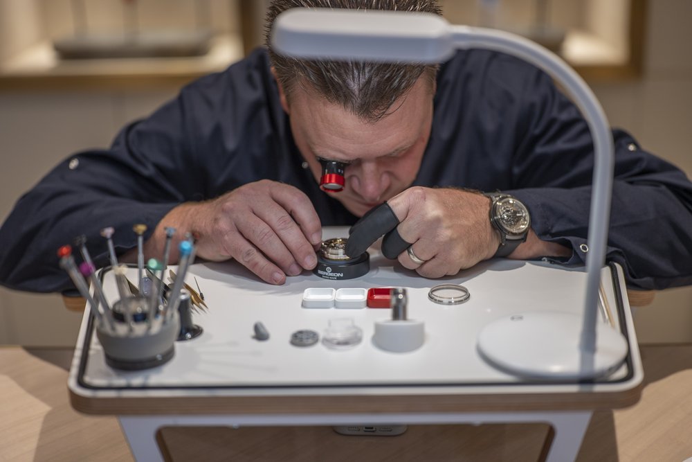 The watchmaker examining the Freak movement through a loupe