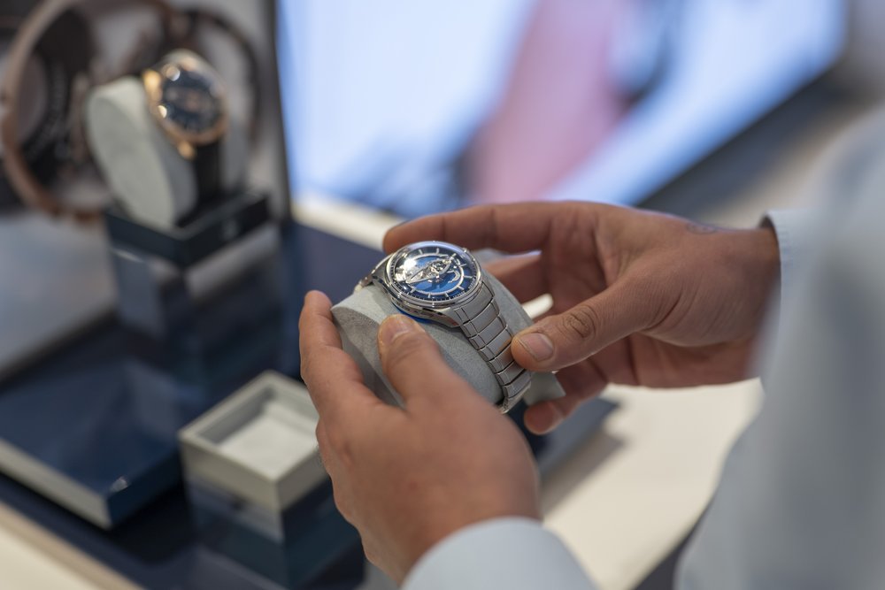 Blue-dial Freak X on a steel bracelet, held in hand